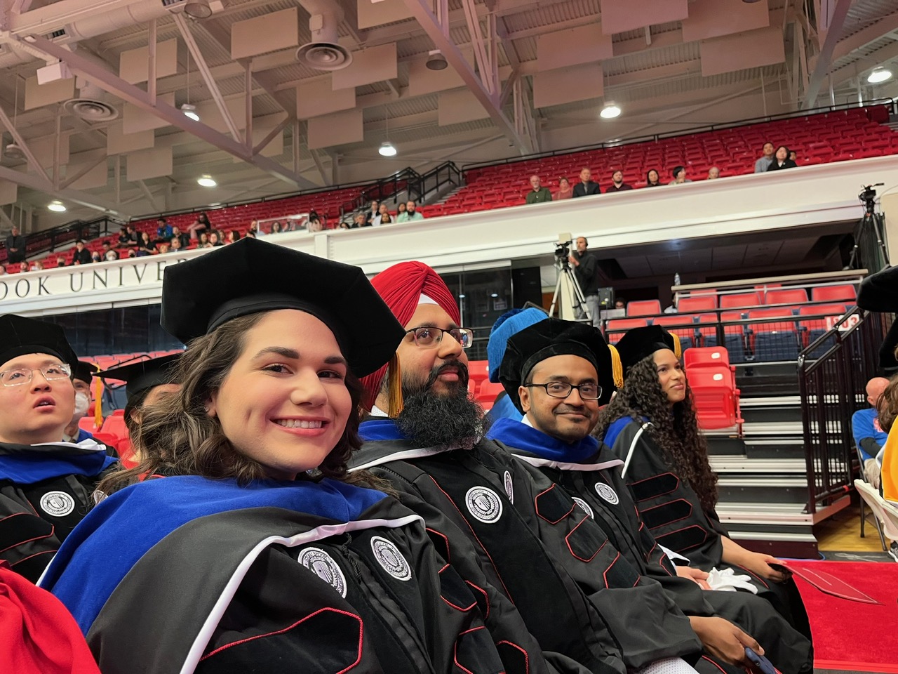 Two students smiling in caps and gowns