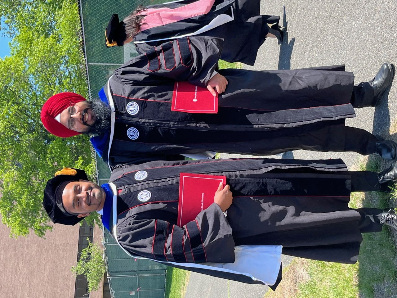 Two students holding diplomas