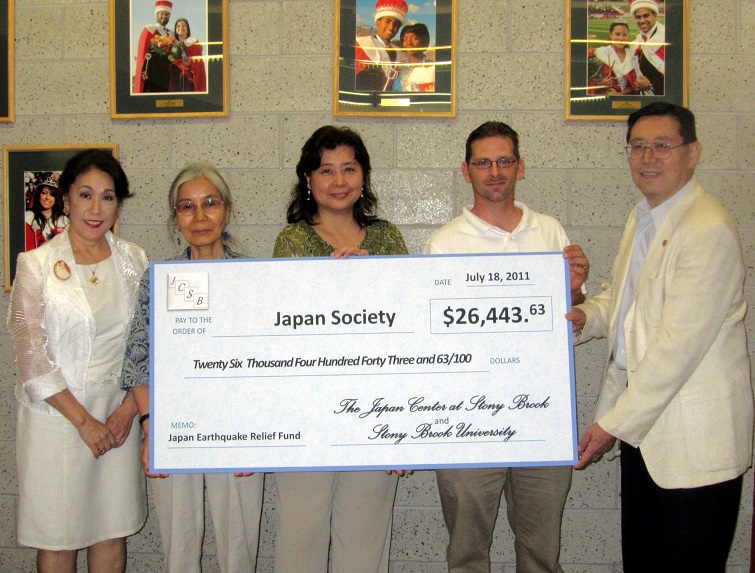 Photo of a big poster of a check for $26,443 held by fundraising committee members