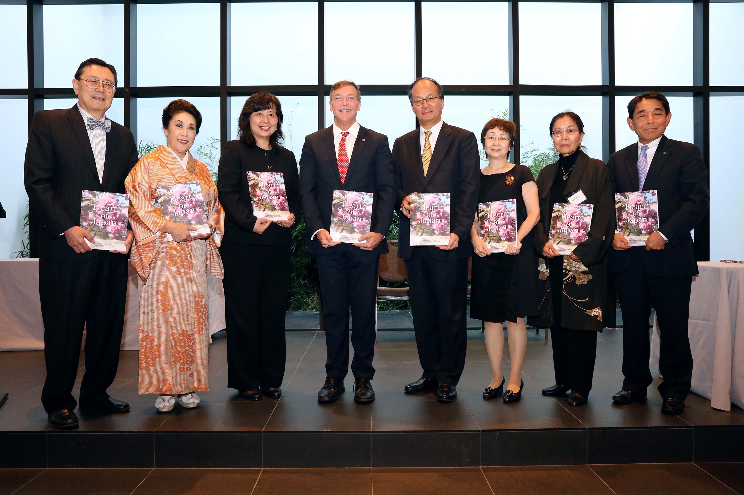 Photo of Japan Center members and their guests holding the newly published copies of Heart of Japan