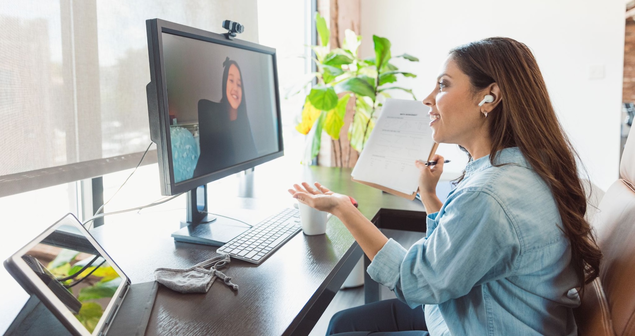 Woman speaking to someone over video conference on a computer monitor