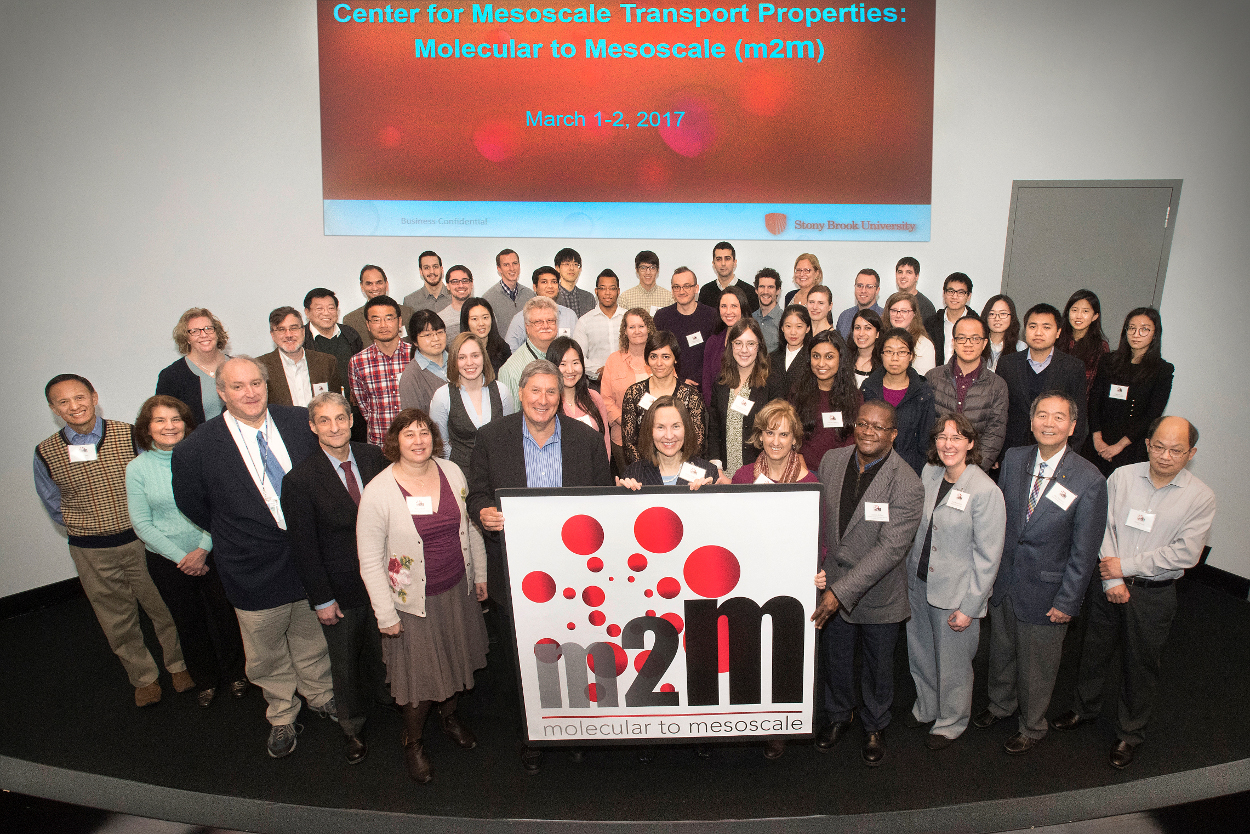 Group of people holding an m2M sign