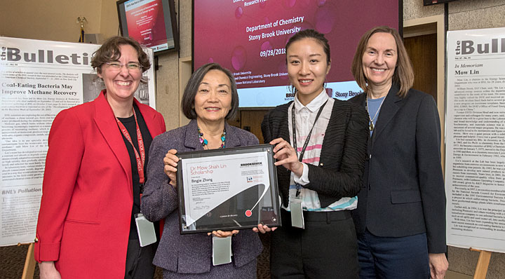 Four people holding an award