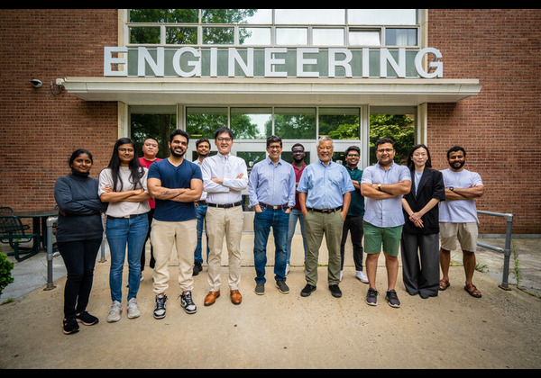 MSCE faculty and graduate students posing together in front of the Engineering building entrance