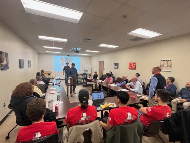 Students, faculty, and IAB members seated at conference room table