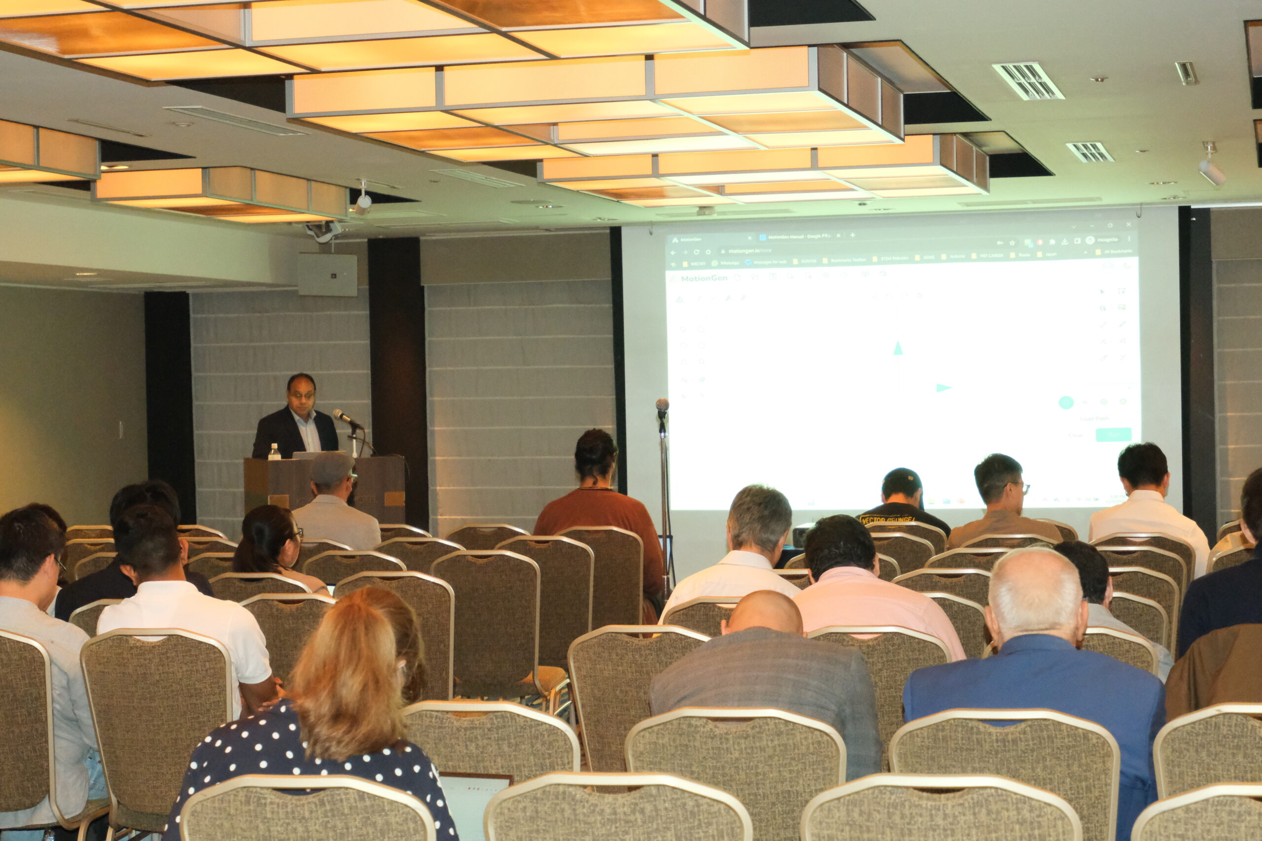 Professor Purwar stands at a podium in front of conference attendees