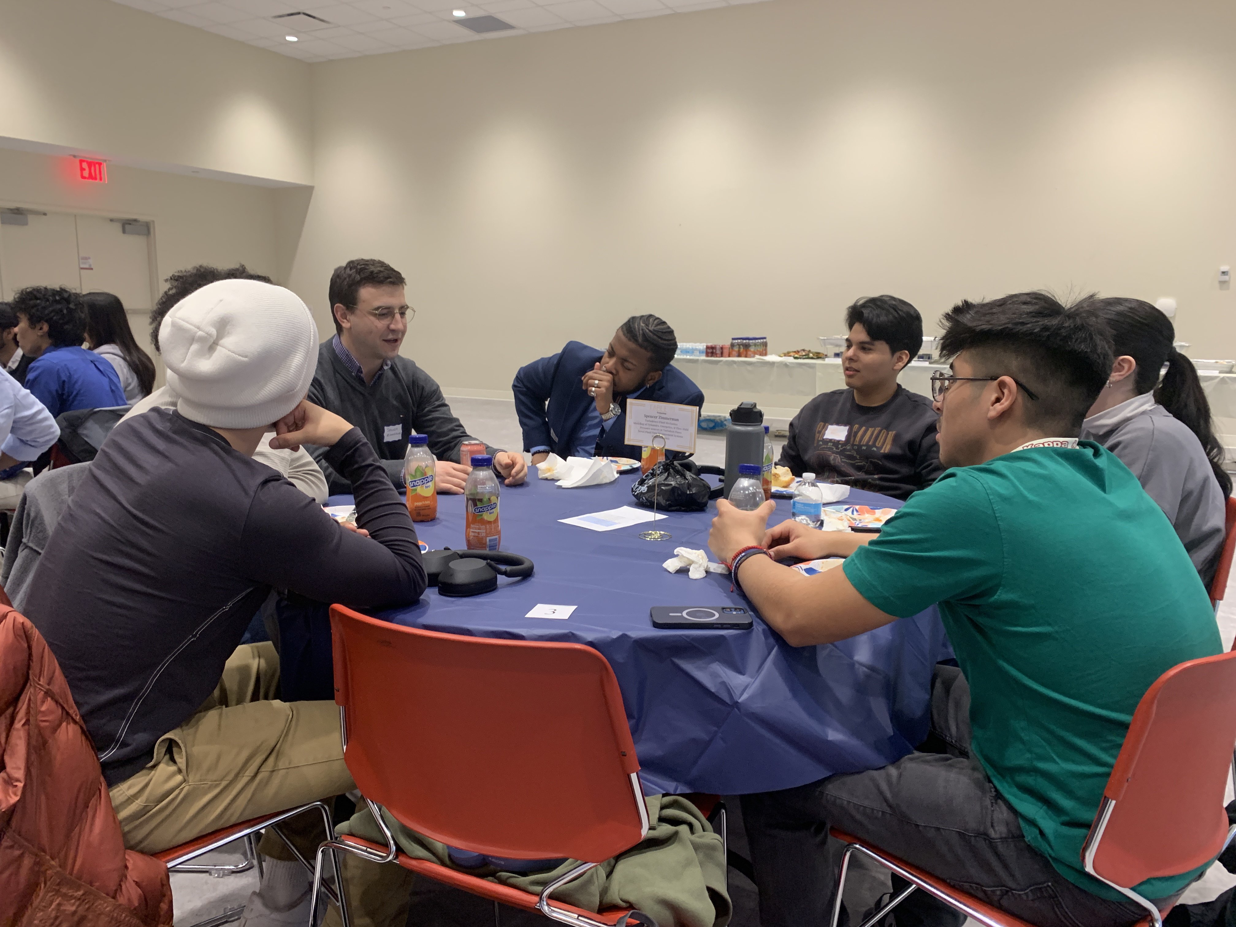 Students and professor Spencer Zimmerman converse at the ASME Networking event