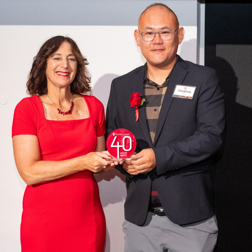 Changhong Cao and President Andrea Goldsmith  pose together while holding a red “40 Under Forty” award.