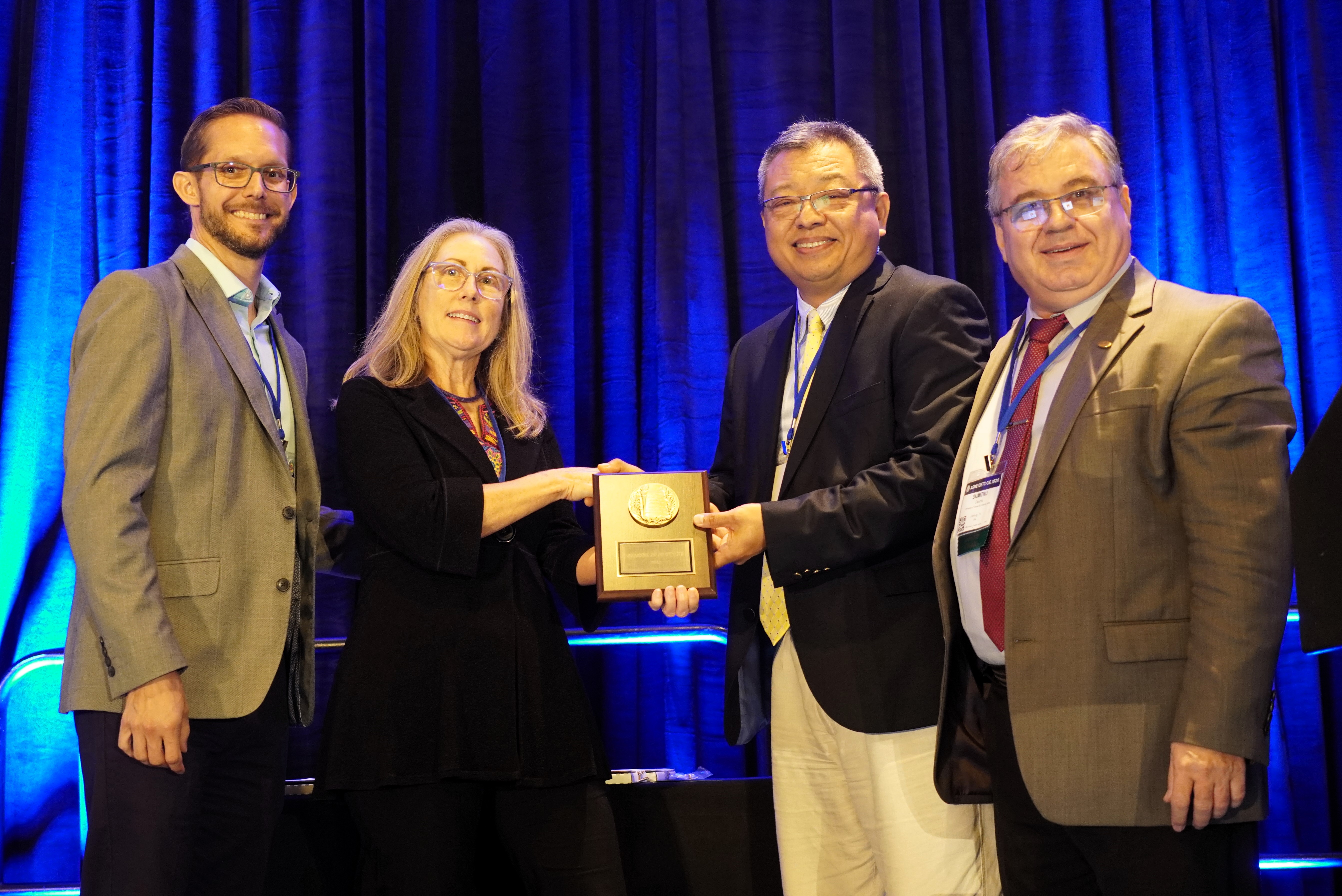 Professor Ge poses with his dedicated service award along side of ASME officials
