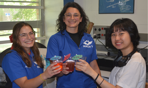 Three individuals raise colorful mocktails in the Maker Space
