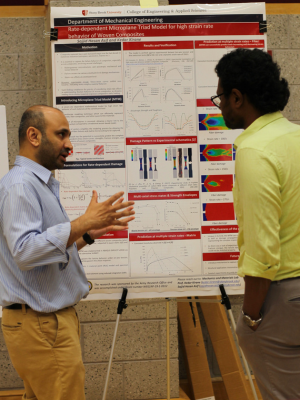 Professor Kirane discusses a research poster with a student