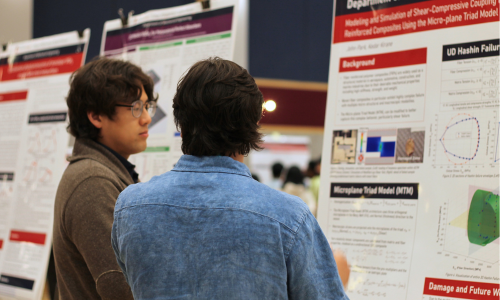 Students discuss a research poster on an easel