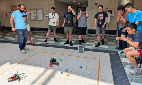 Students cheer on their robots as they compete to retrieve and return rubber ducks to a designated location