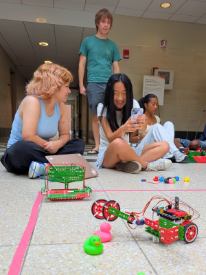 Students watch as their SnappyXO robot attempts to pick up a pink rubber duck 