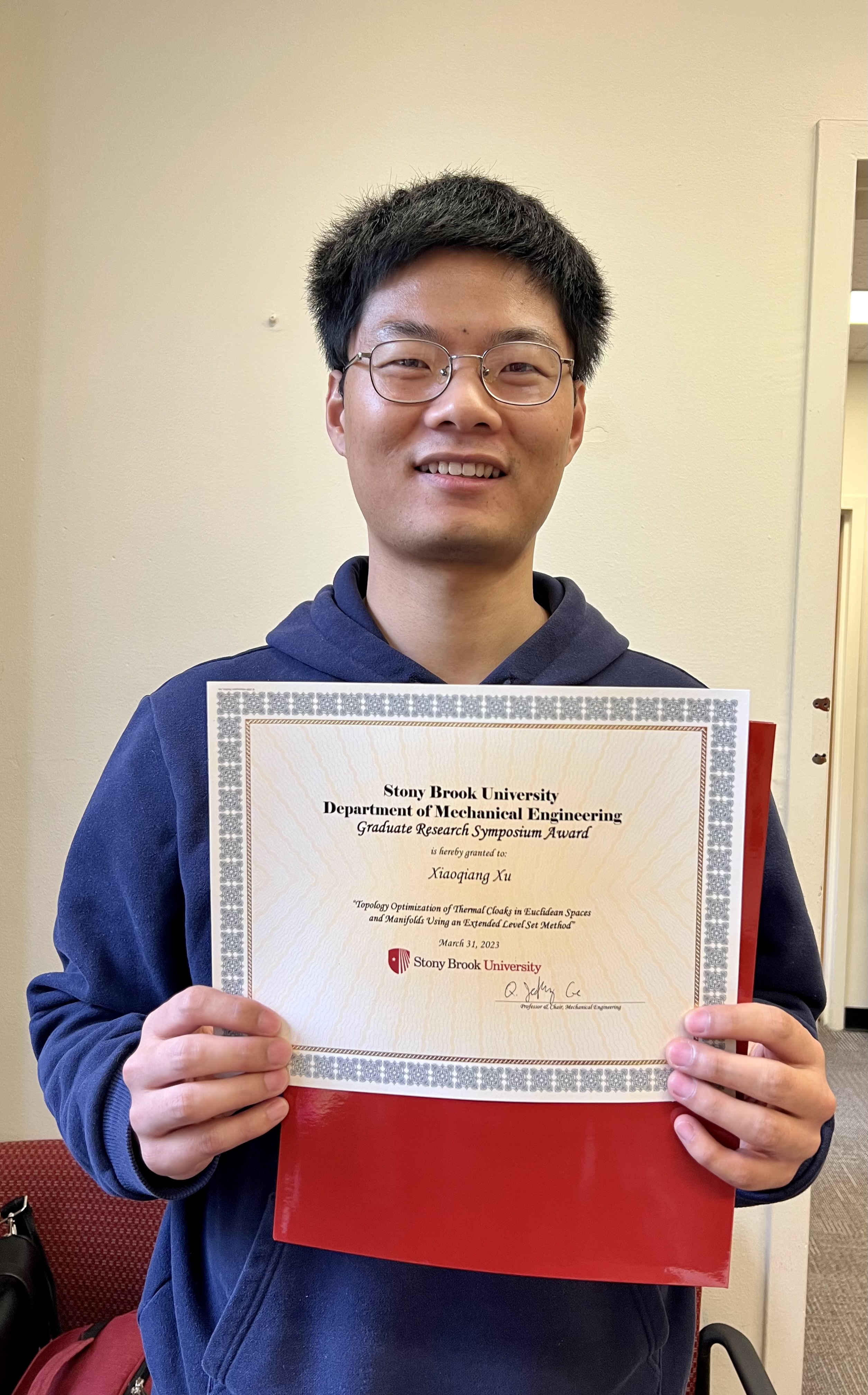 Graduate student, Xiaoqiang Xu poses with certificate