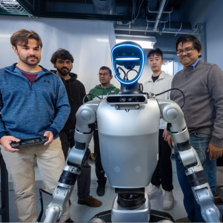 Students gathered around a robot. 