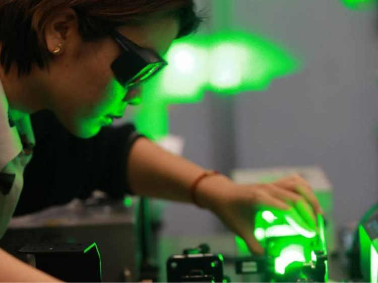 Student wearing goggles working with a green laser
