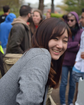 Ji Young Park; Girl with brown hair and gray cardigan smiling