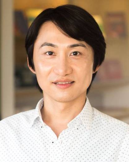 Headshot of Julian Chen in white dotted collar shirtand bright background