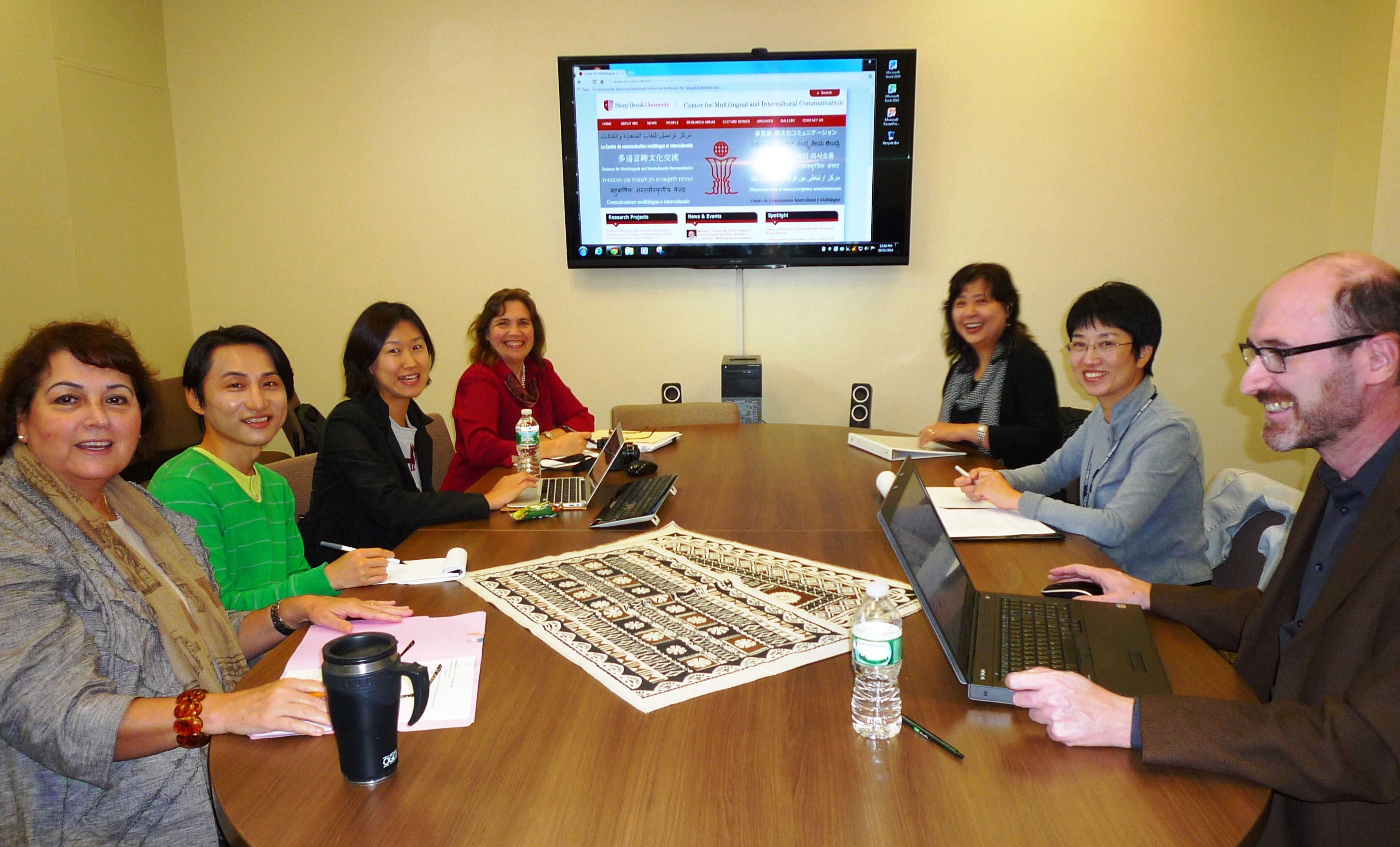 Agnes_Lilia_Jiwon_Sarah_Eriko Projects members sitting around the conference table and looking towards the camera.