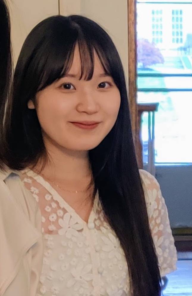 Headshot of Kayo Takahashi with black long hair and bangs wearing a white shirt