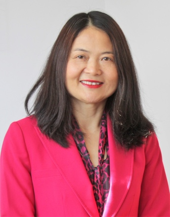 Guofang smiling with brown hair and wearing a pink suit
