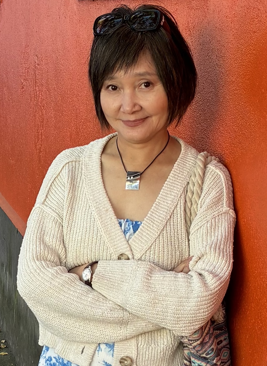 headshot of Hansun Zhang Waring in white outwear leaning against the wall