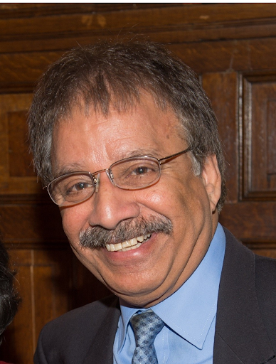 Headshot of Tej Bhatia with glasses and suit tie