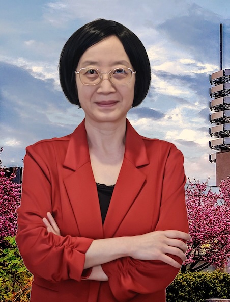 Agnes he smiling with arms crossed, wearing a red blazer