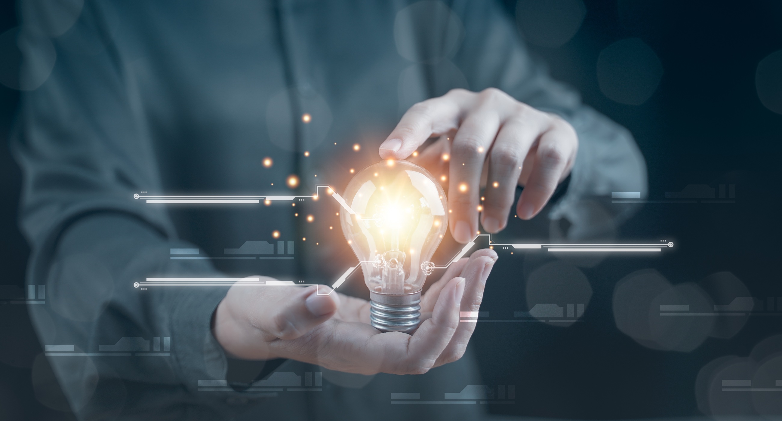 Person holding illuminated light bulb