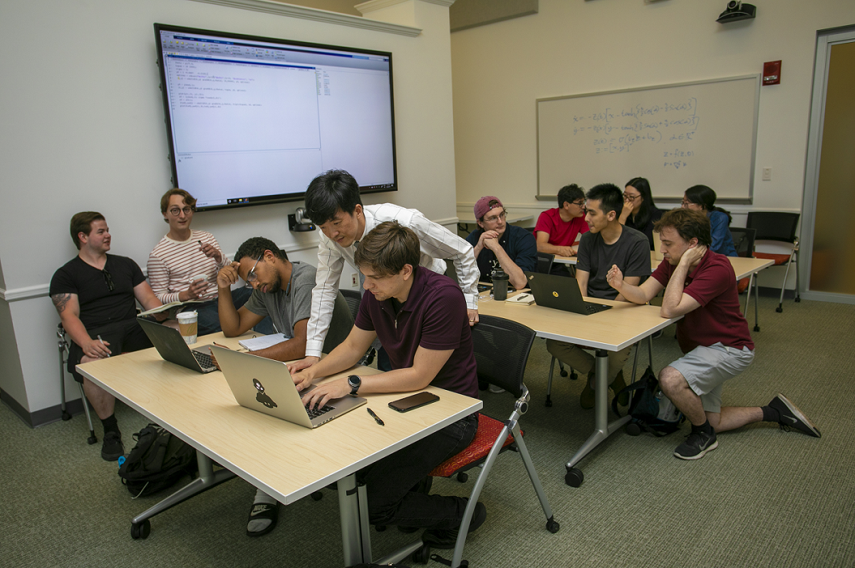 Students and instructors working on laptops