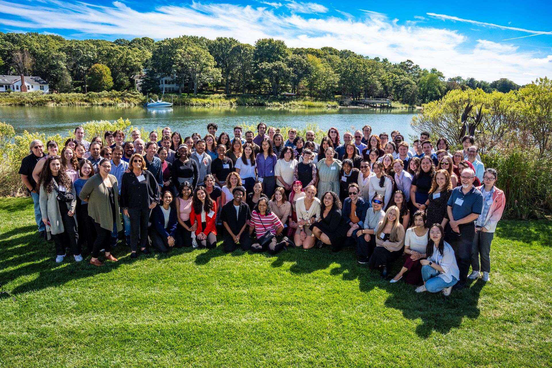 Group picture of the members of the Department of Neurobiology & Behavior standing in frontof a lake.