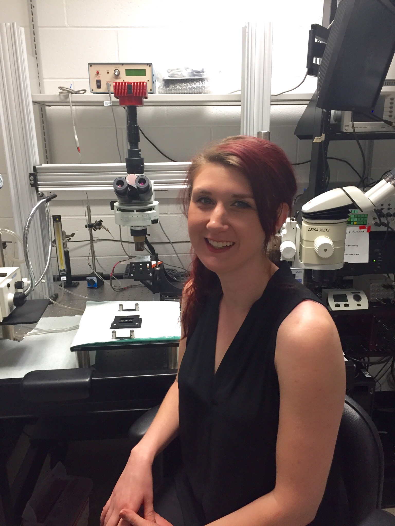 Lindsey Czarnecki sitting in front of a microscope