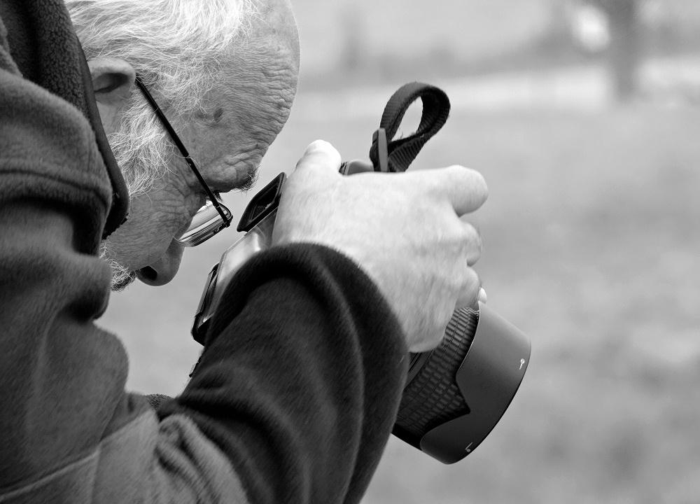 A photographer looking through the viewfinder of a camera
