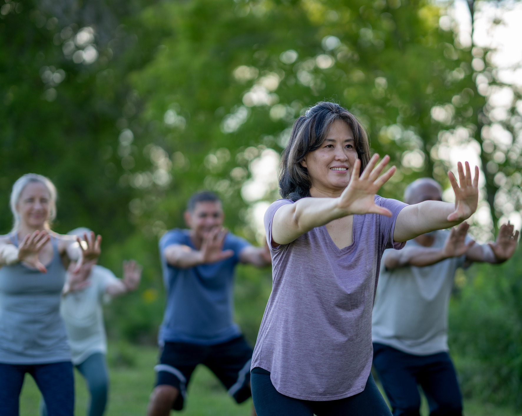 Four people practicing Tai Chi outdoors