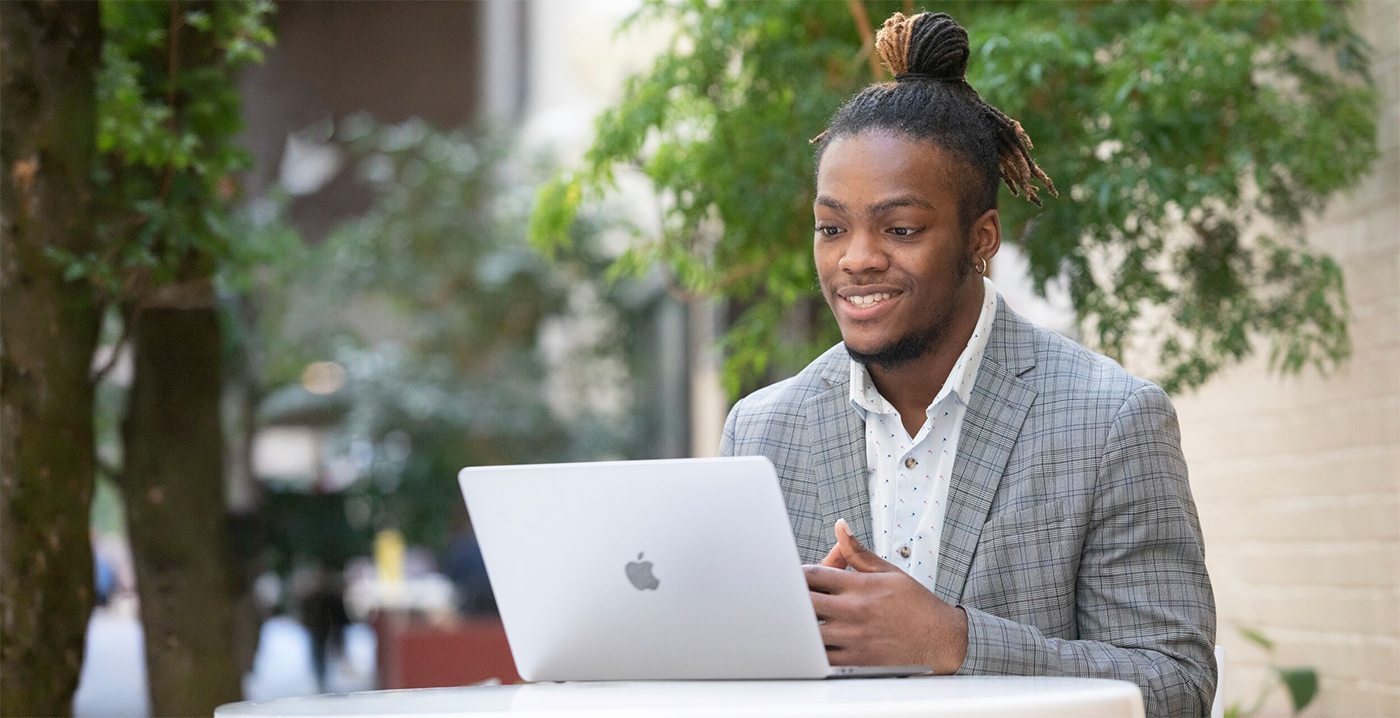 An online education student conversing with his professor over Zoom