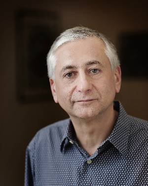 Headshot of Stanley Feldman in front of a dark background.