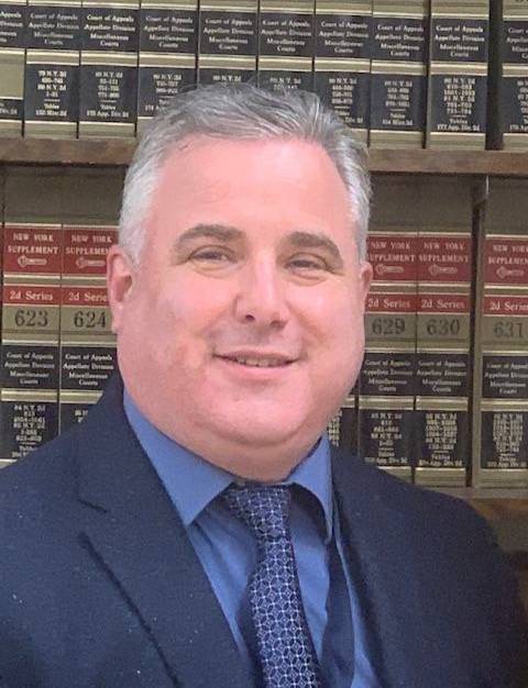 David Scott in front of a bookshelf