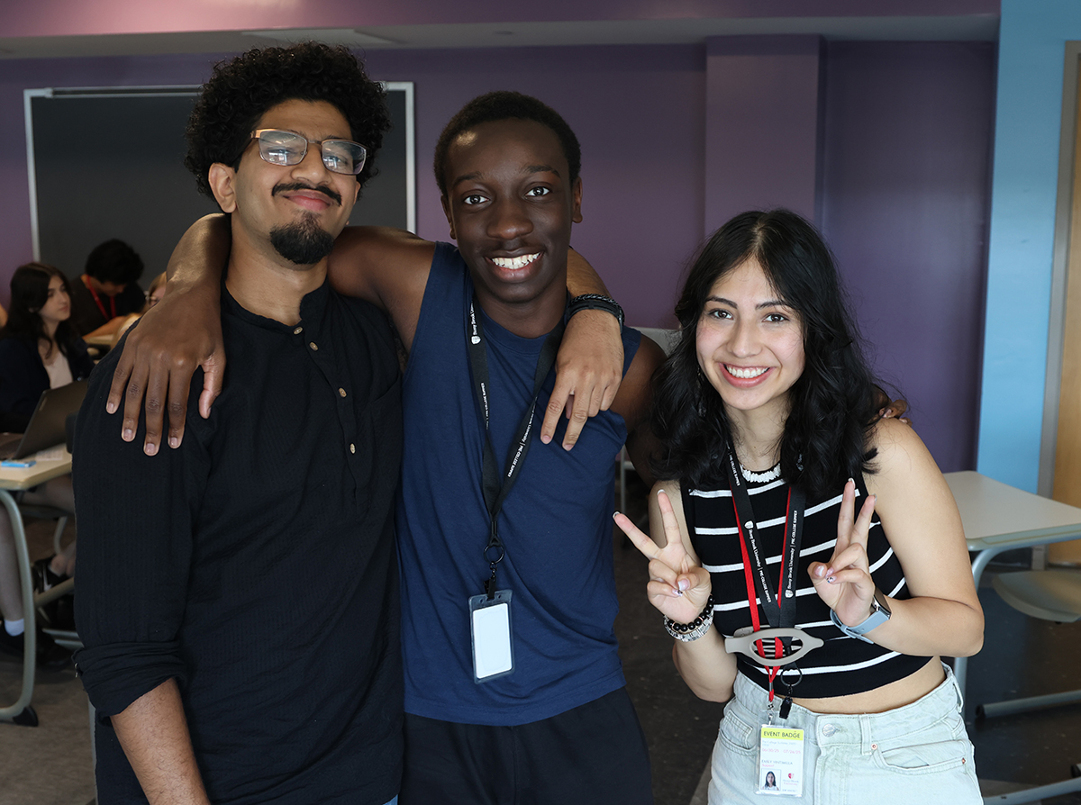 Three PCS program ambassadors smiling after taking the Pre-Law participants to their classroom