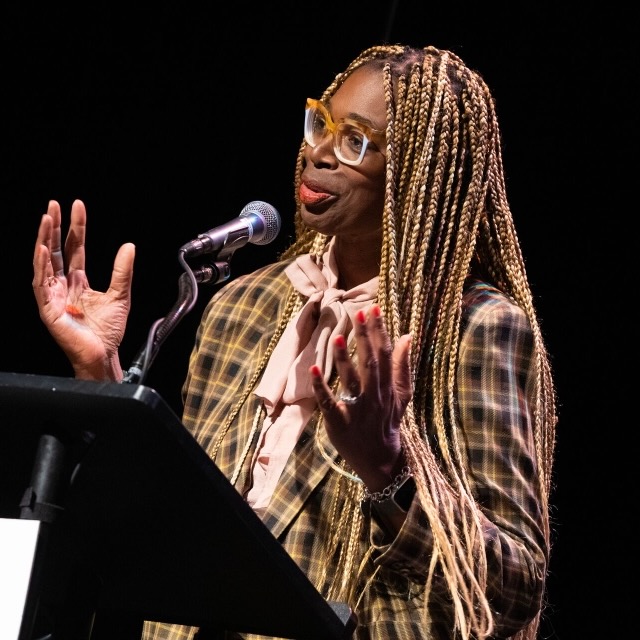A faculty member gives a lecture at a podium