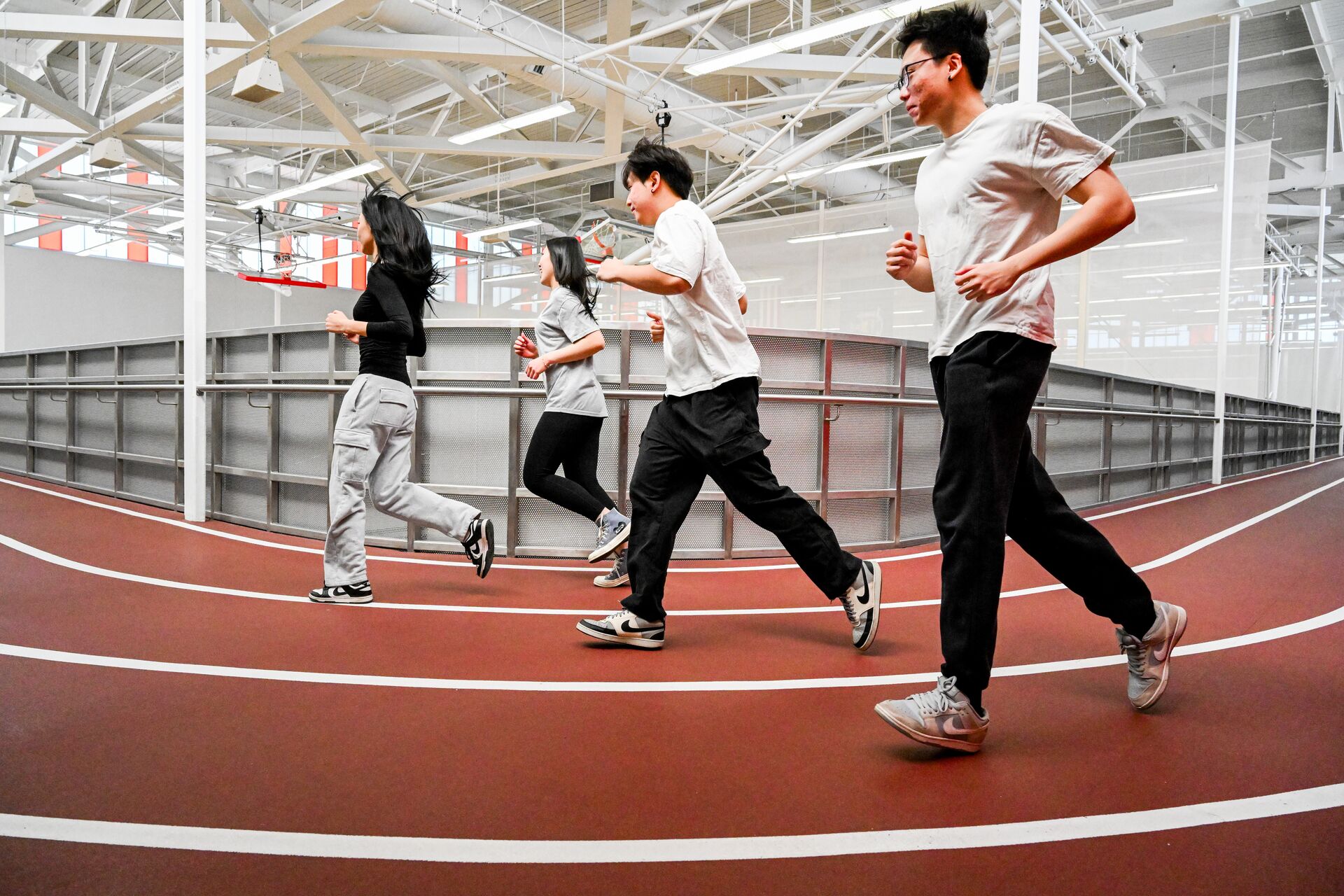 Four students running on the indoor track.