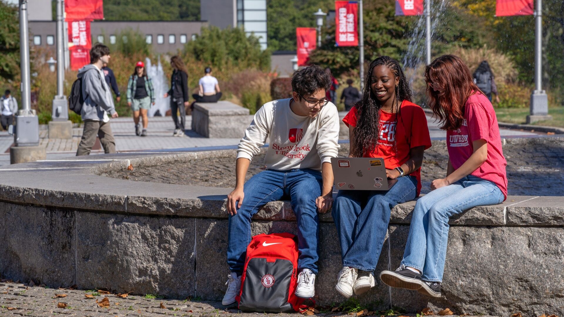 students sitting at a fountain