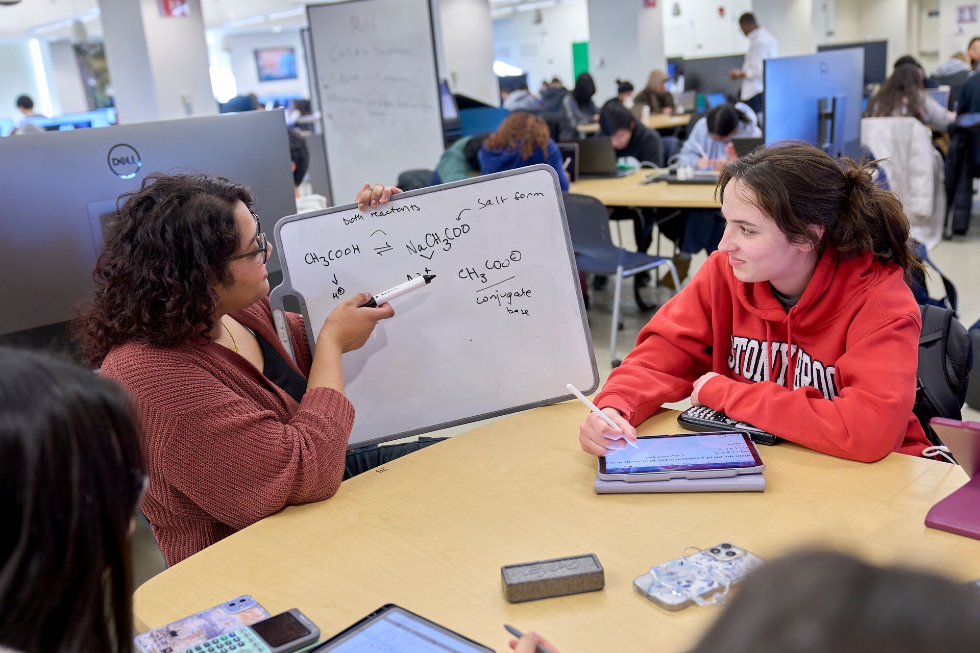 Students working on a whiteboard together.