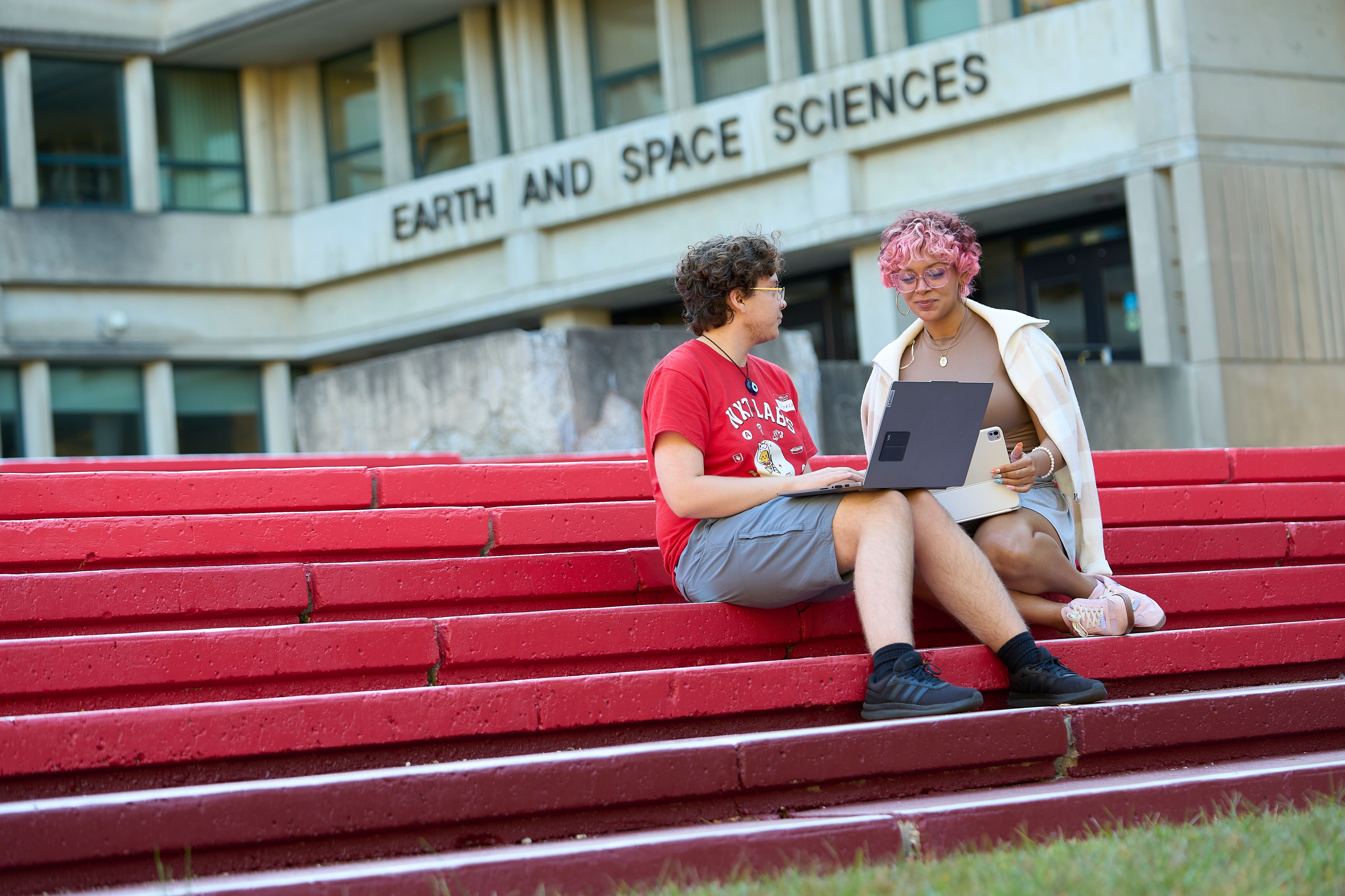 two students sitting on the steps of the Earth and Space Sciences building