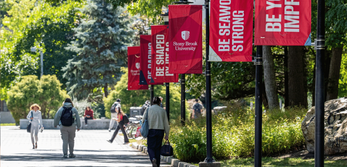 Students walking down the academic mall with stony brook banners hanging