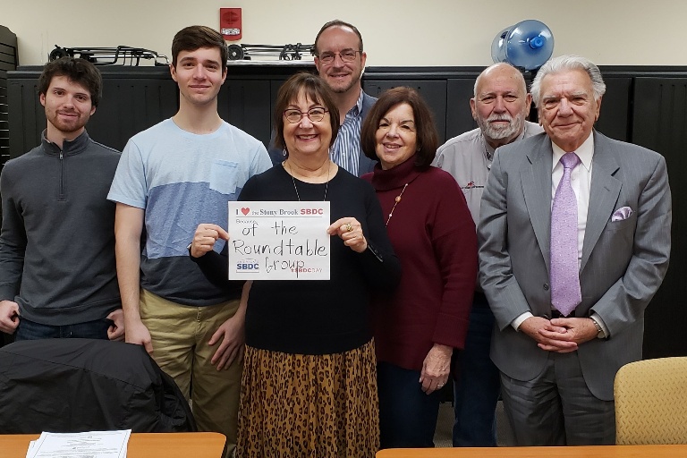 Ronni Rosen with members of the SBDC roundtable holing an "I Love the Stony Brook SBDC" sign