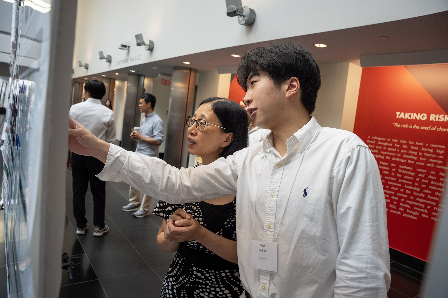 Simons Fellow explains his poster at research symposium