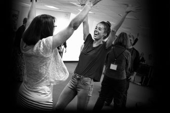 Students during a workshop smiling with their hands raised in the air. Students during a workshop smiling with their hands raised in the air.