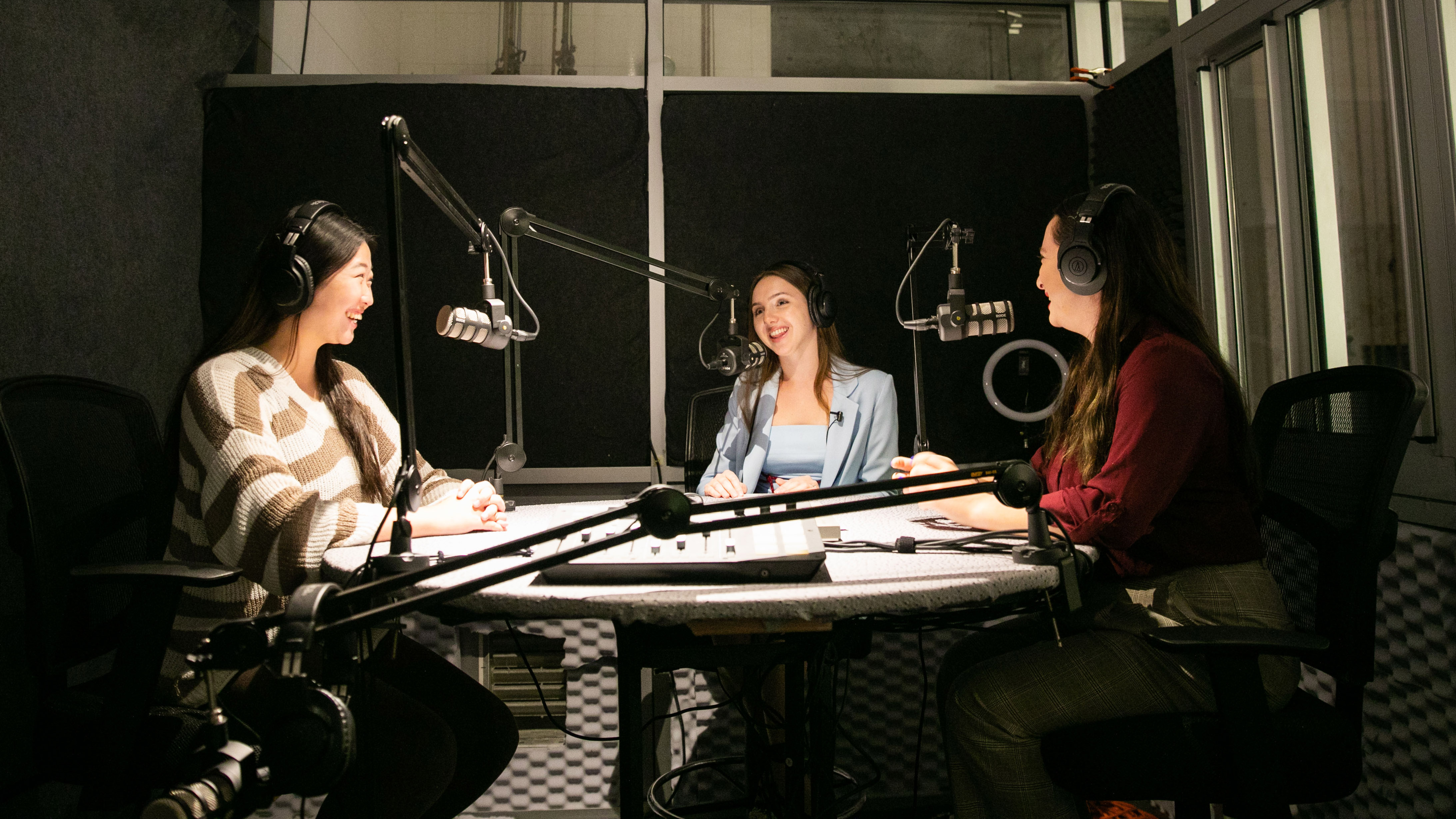 Three students recording a podcast in the School of Communication and Journalism's podcast studio.