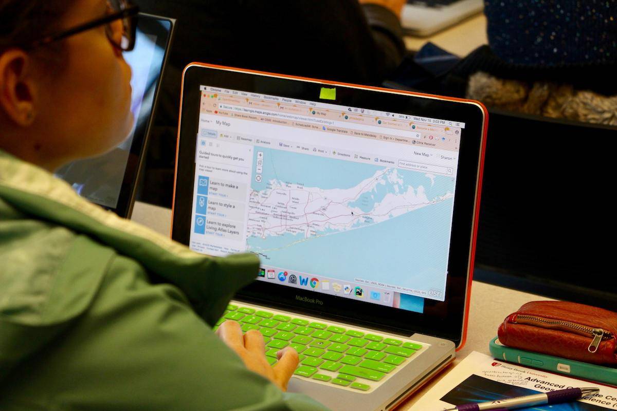 A student works on a GIS project on their laptop